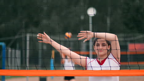 Four-girls-volleyball-players-play-on-the-beach-in-the-summer-participating-in-the-tournament-in-slow-motion-on-the-sand